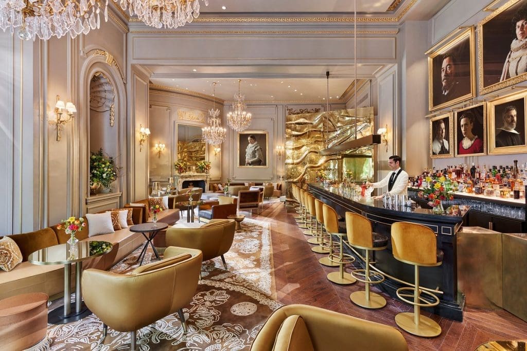 Lobby de hotel de 5 estrellas con decoración clásica y barra de cócteles en Madrid